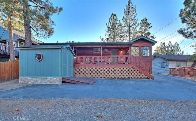 view of front of house with fence and an outdoor structure