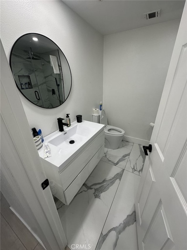 bathroom featuring vanity, toilet, and a shower with shower door