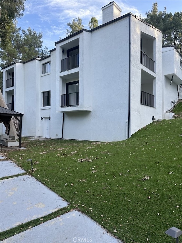 view of side of home with a gazebo and a lawn