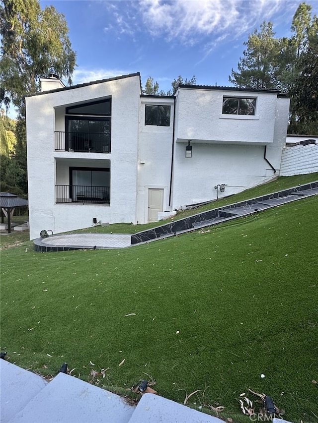 exterior space with a balcony and a yard