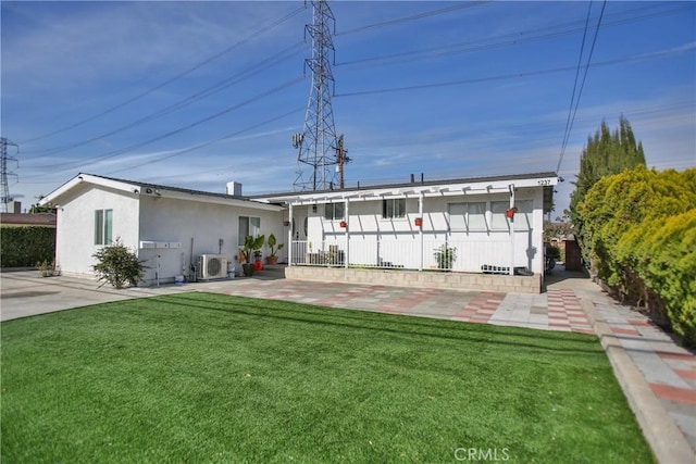 back of house featuring a lawn and ac unit