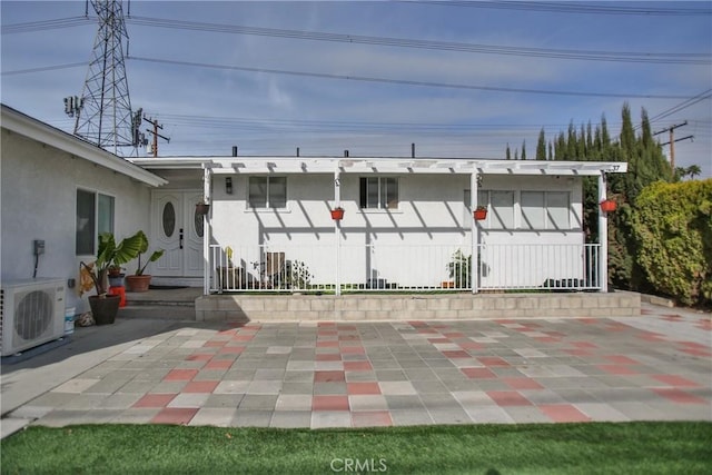 view of front of property with ac unit and a patio