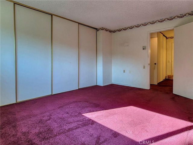 unfurnished bedroom with carpet, a textured ceiling, and a closet