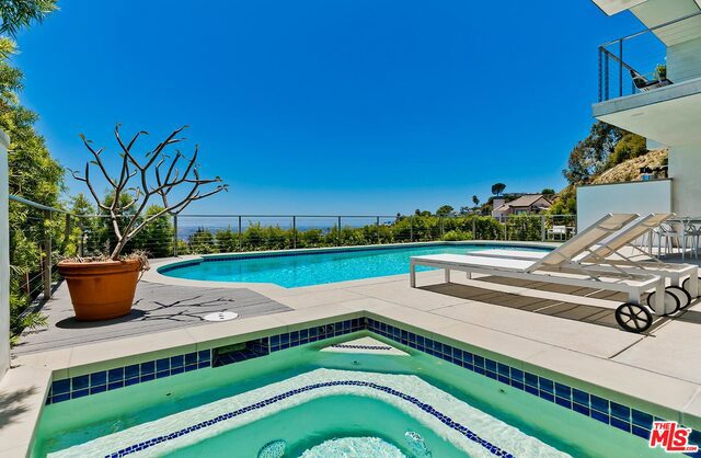 view of pool with an in ground hot tub and a patio