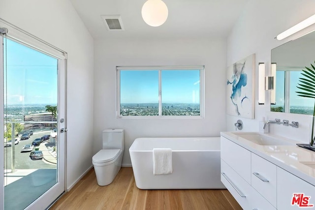 bathroom with a tub to relax in, hardwood / wood-style flooring, and a wealth of natural light