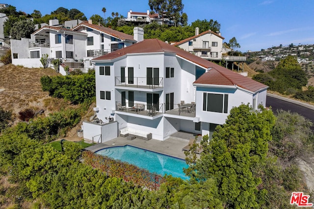 back of property featuring a balcony and a patio