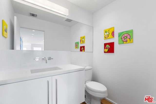 bathroom featuring vanity, toilet, and wood-type flooring