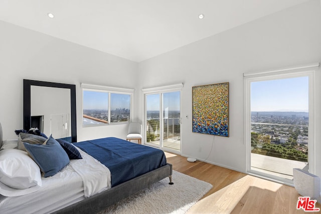 bedroom with access to exterior and wood-type flooring