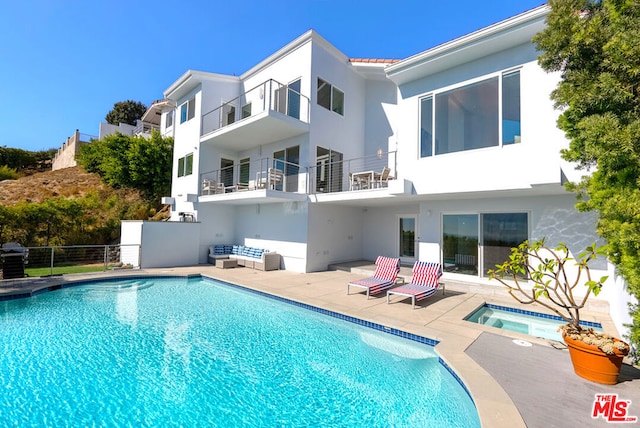 back of house featuring a pool with hot tub and a patio