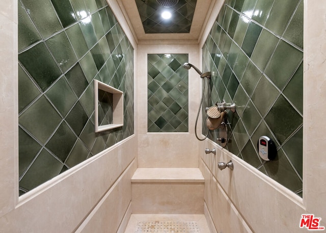 bathroom with tile patterned floors, tile walls, and tiled shower