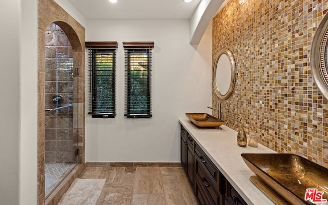 bathroom featuring tasteful backsplash, vanity, and a shower with shower door