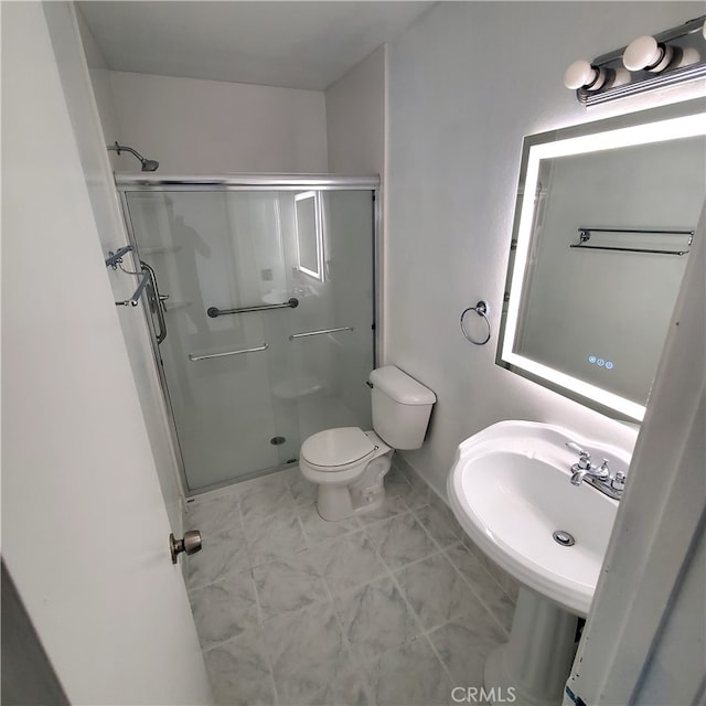 bathroom with toilet, an enclosed shower, and sink