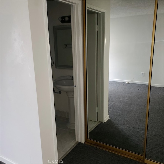 corridor featuring carpet flooring and a textured ceiling