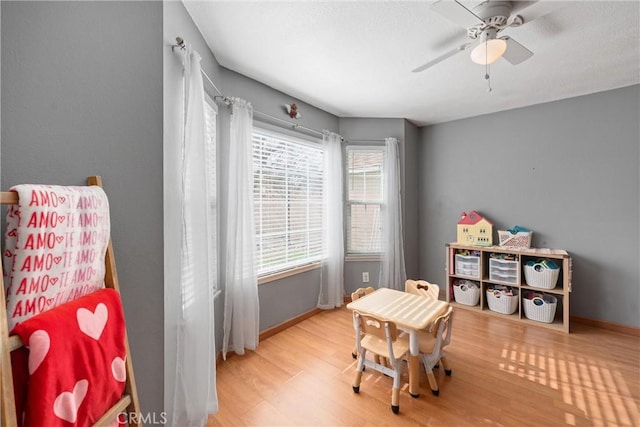 recreation room featuring light hardwood / wood-style floors and ceiling fan