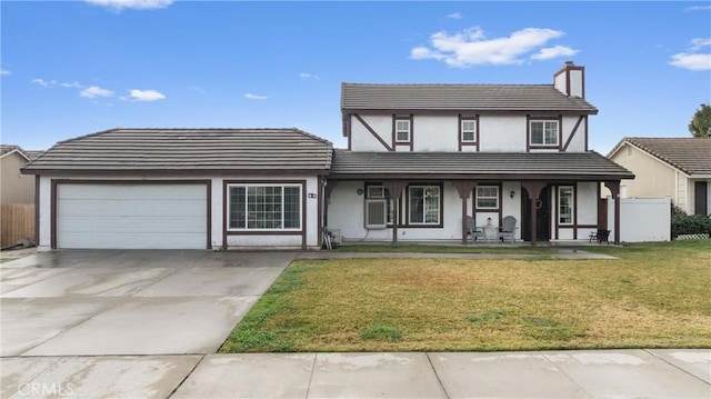 view of front of house featuring a garage, covered porch, and a front lawn