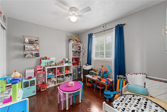 game room featuring dark wood-type flooring and ceiling fan