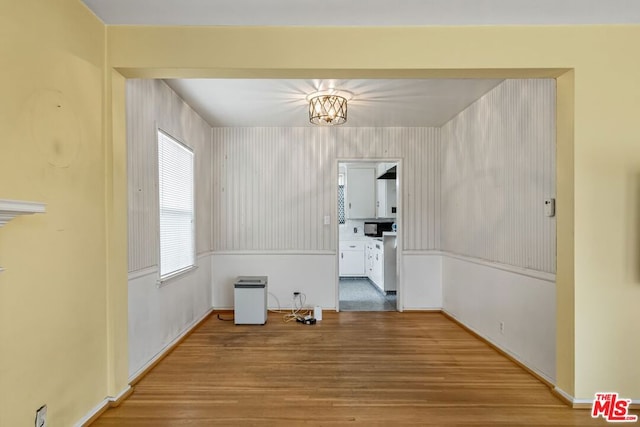 unfurnished dining area with hardwood / wood-style floors and an inviting chandelier