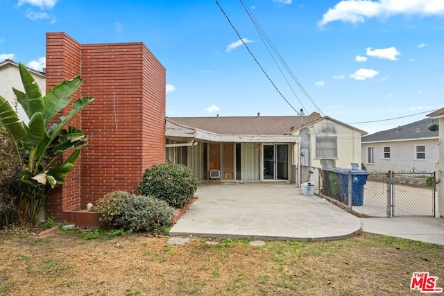 rear view of house with a yard and a patio area