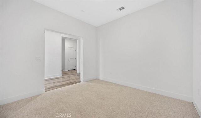 unfurnished room with light carpet, baseboards, and visible vents