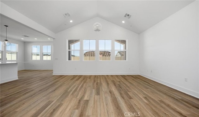 spare room with lofted ceiling, visible vents, and wood finished floors