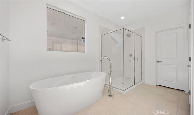 bathroom featuring a stall shower, baseboards, a soaking tub, and recessed lighting