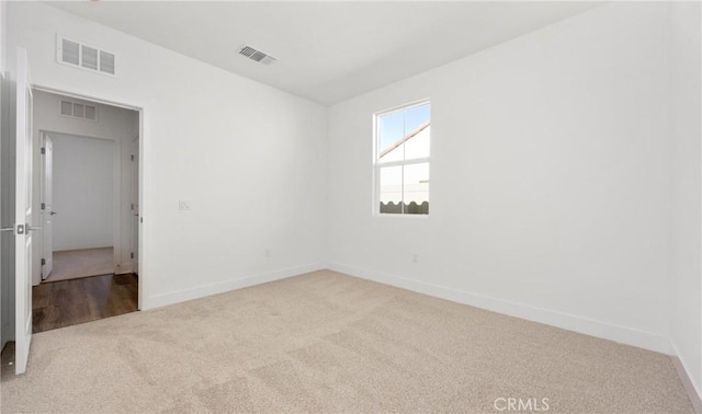 unfurnished room with light carpet, baseboards, and visible vents