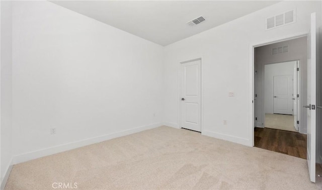 unfurnished bedroom featuring light carpet, baseboards, and visible vents