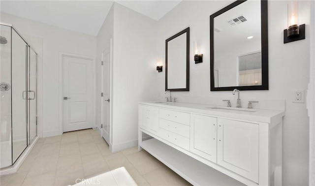 full bathroom featuring double vanity, a stall shower, visible vents, and a sink