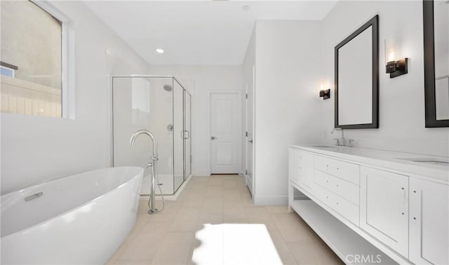 bathroom with a stall shower, a sink, a freestanding bath, and double vanity