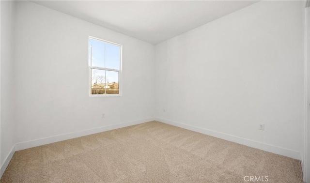 carpeted spare room featuring baseboards