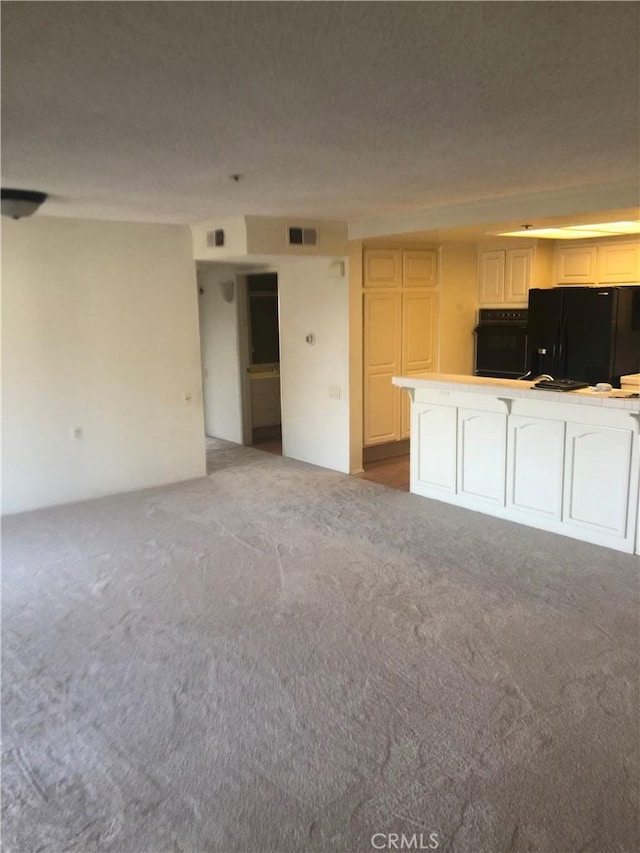 unfurnished living room with light colored carpet