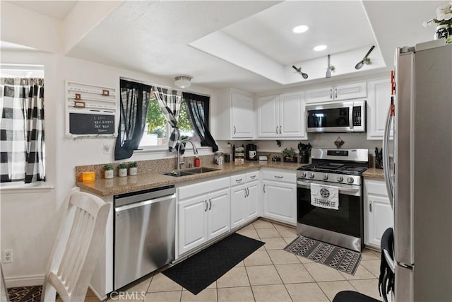 kitchen with white cabinets, sink, light stone countertops, light tile patterned floors, and stainless steel appliances