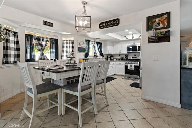 dining area featuring light tile patterned floors, an inviting chandelier, and a raised ceiling