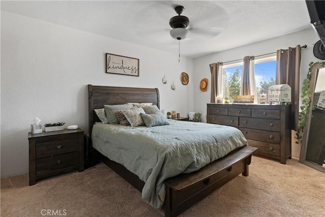 bedroom featuring ceiling fan, light colored carpet, and a textured ceiling