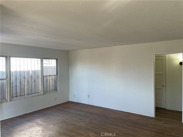 unfurnished room with dark hardwood / wood-style flooring