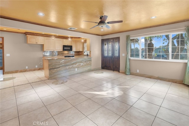 kitchen with ceiling fan, kitchen peninsula, crown molding, and light tile patterned floors