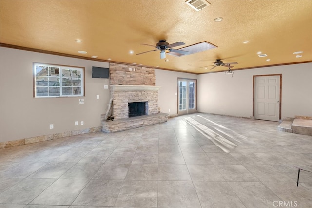 unfurnished living room featuring crown molding, a fireplace, and a textured ceiling