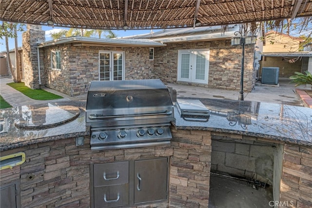 view of patio with french doors, central AC, area for grilling, and grilling area