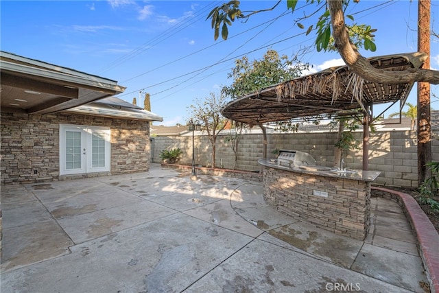 view of patio with french doors and an outdoor kitchen