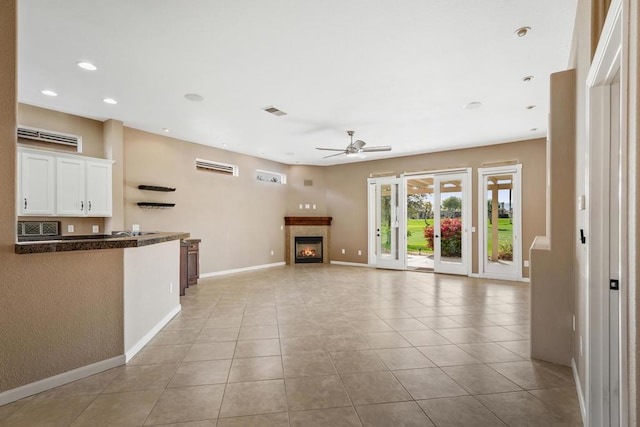 unfurnished living room featuring light tile patterned floors and ceiling fan