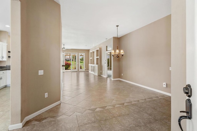 interior space featuring light tile patterned floors and ceiling fan with notable chandelier