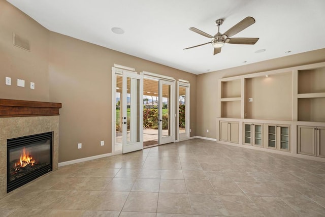 unfurnished living room featuring a tile fireplace, ceiling fan, built in features, and light tile patterned floors