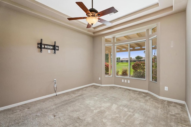 unfurnished room featuring carpet flooring, ceiling fan, and a raised ceiling