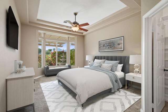 bedroom featuring carpet flooring, ceiling fan, and a tray ceiling