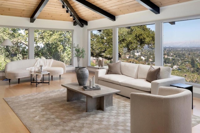 sunroom / solarium featuring lofted ceiling with beams and wooden ceiling