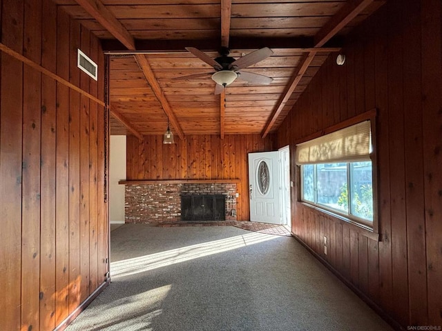 unfurnished living room with ceiling fan, carpet floors, a fireplace, wooden walls, and wood ceiling