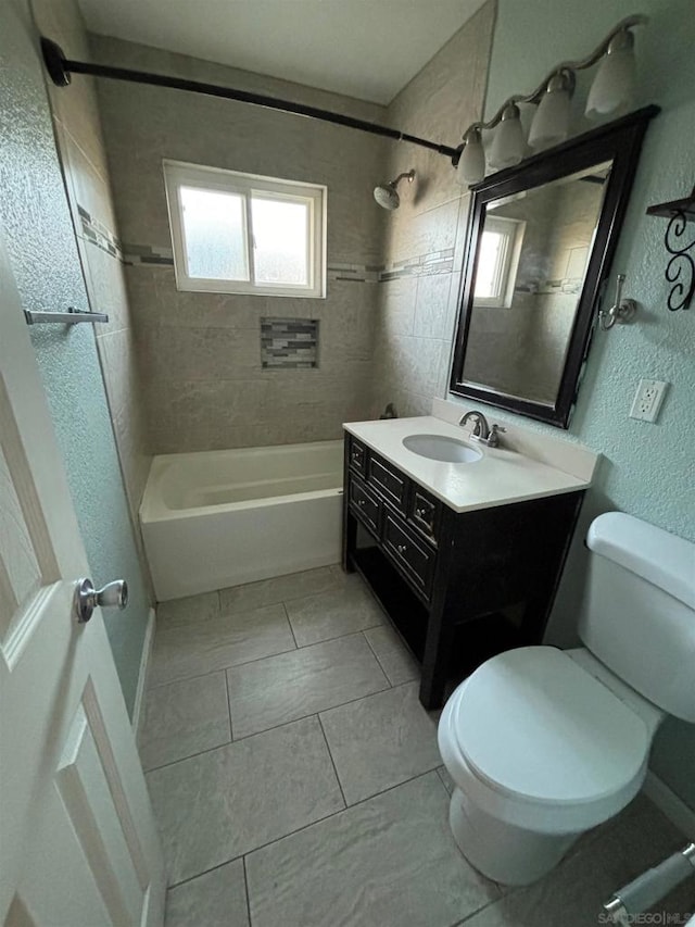 full bathroom featuring toilet, tiled shower / bath combo, tile patterned floors, and vanity