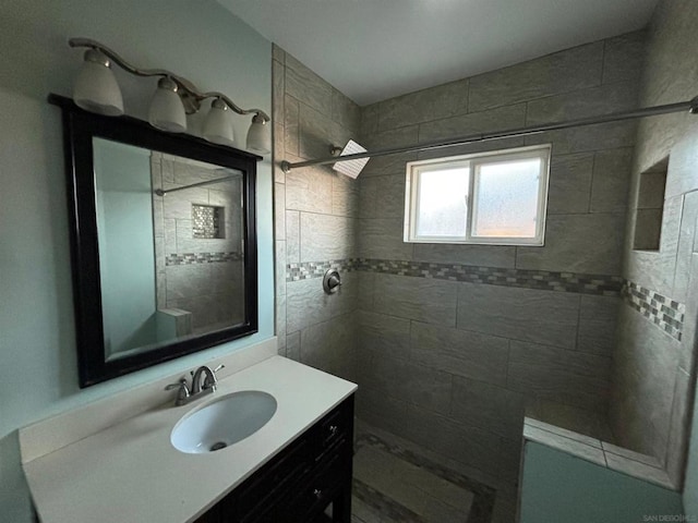 bathroom featuring a tile shower and vanity