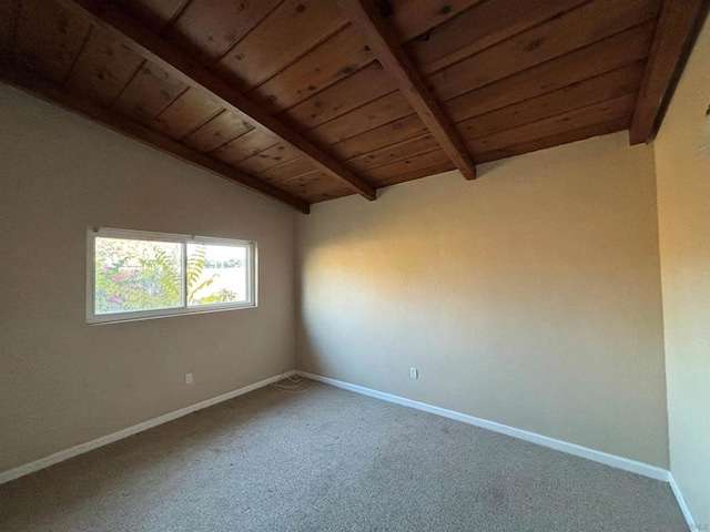 empty room featuring carpet floors, lofted ceiling with beams, and wood ceiling