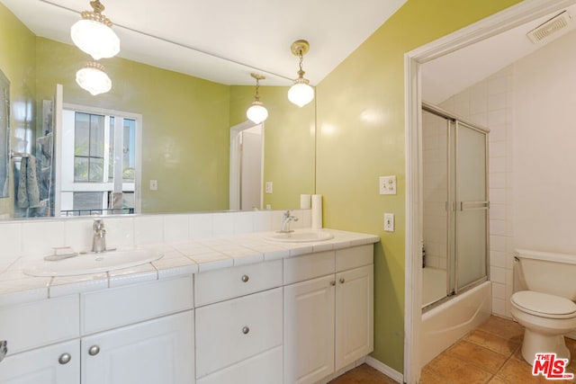 full bathroom featuring vanity, enclosed tub / shower combo, vaulted ceiling, and toilet